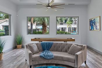 Lounge area with curved sofa and shuffleboard table